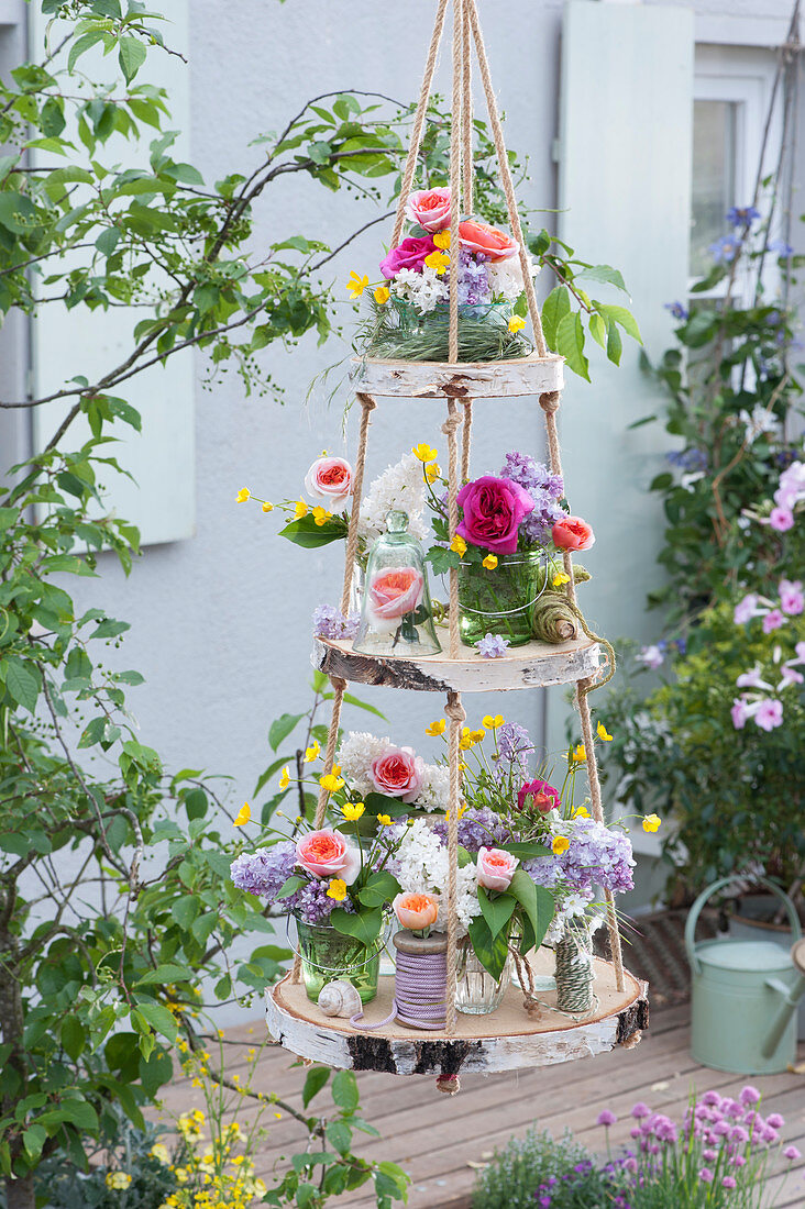 Self-made étagère from birch slices: bouquets of roses, lilacs and buttercups