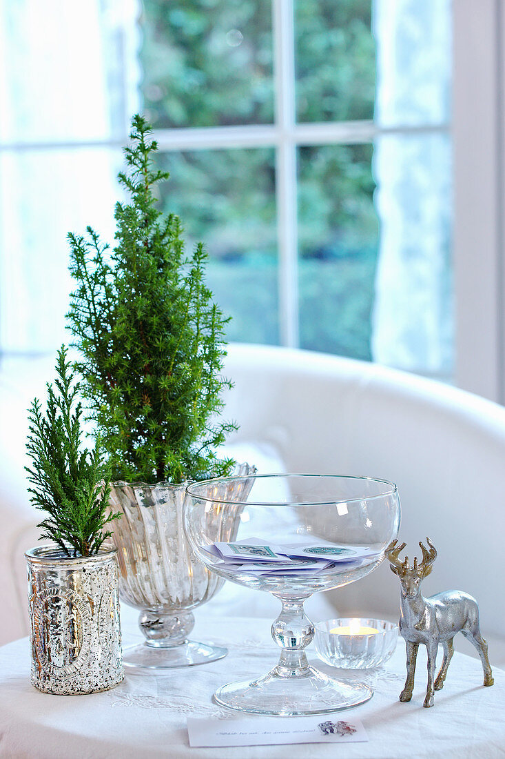 Winter arrangement of conifer in mercury silver containers