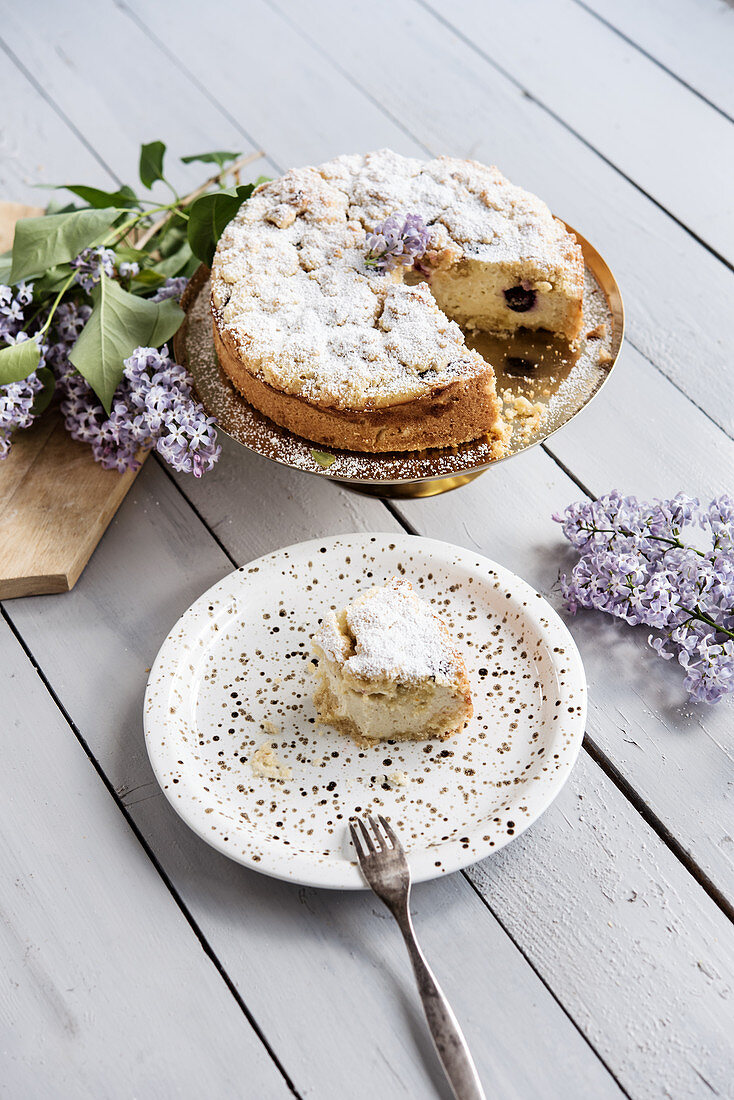 Blueberry crumble cake on a golden cake stand, sliced