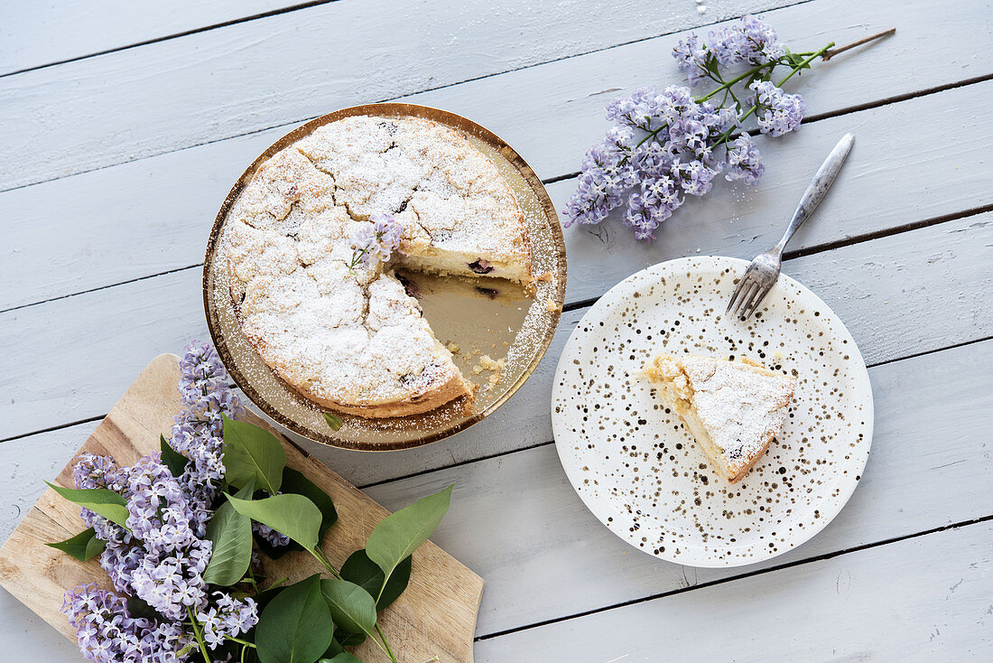 Blaubeer-Streuselkuchen auf goldenem Kuchenständer, angeschnitten