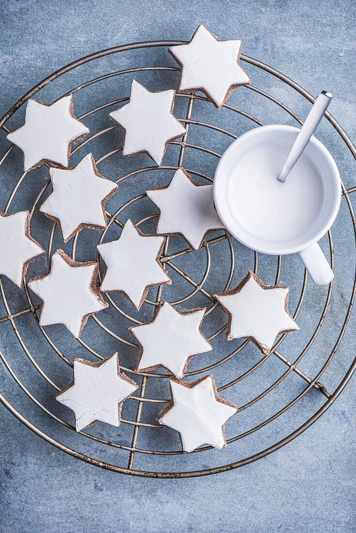 Several cinnamon stars and a cup of eggnog on a cooling grill