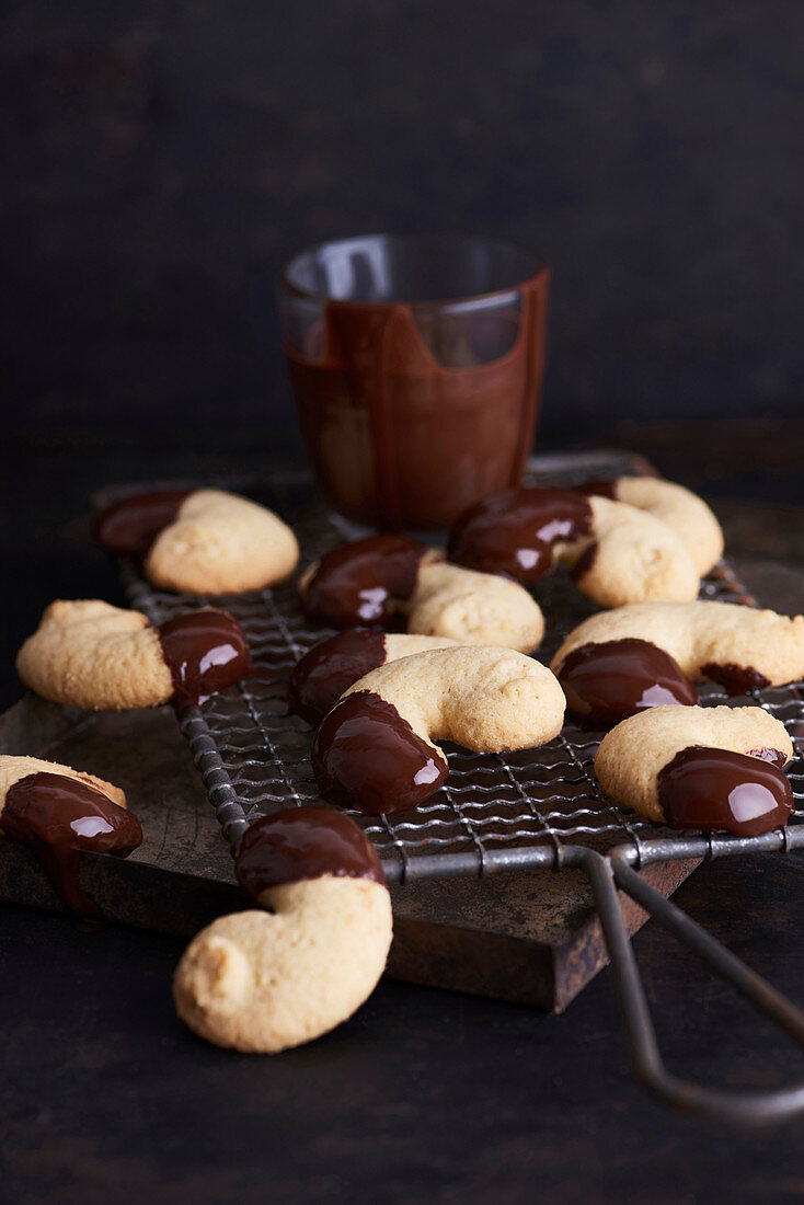 Chocolate-dipped almond biscuits on a cooling rack