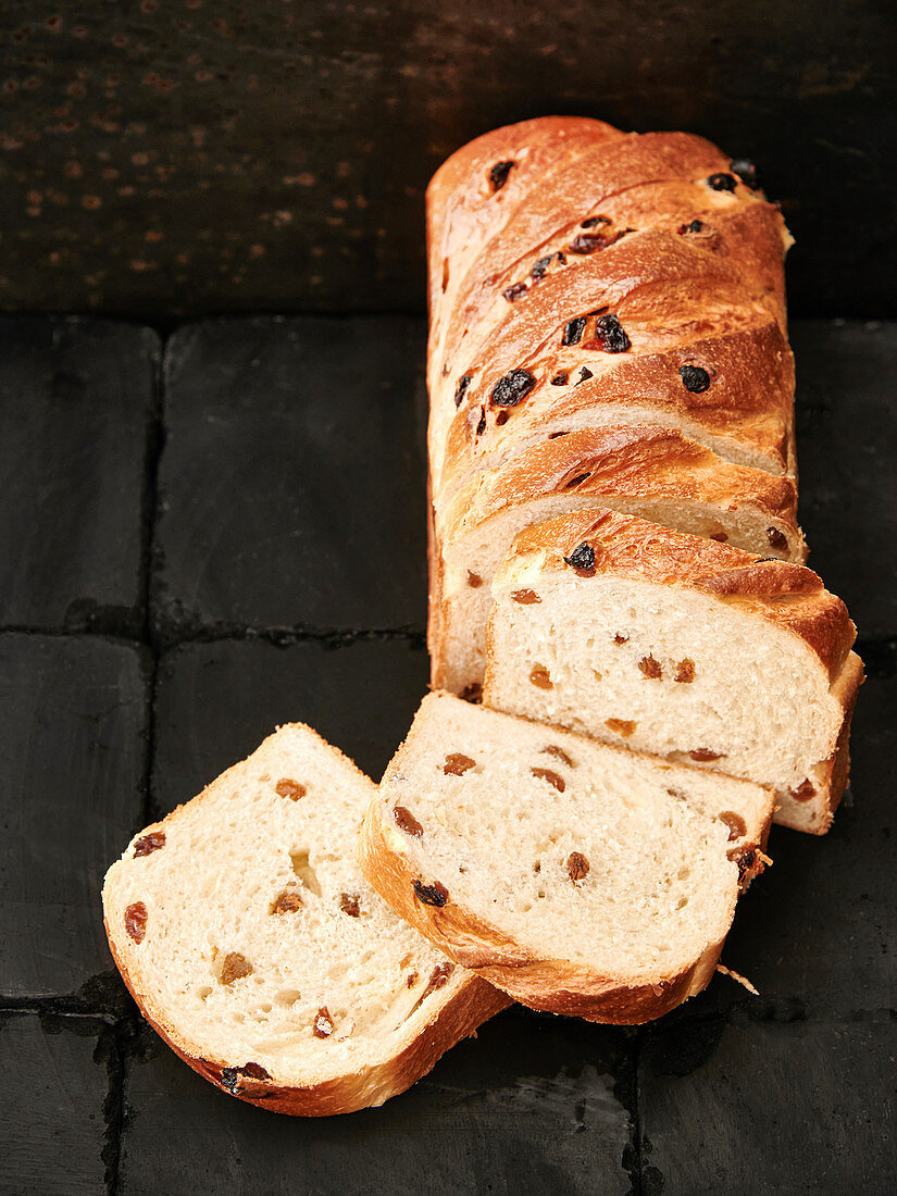 Fruit bread, sliced, on black stones