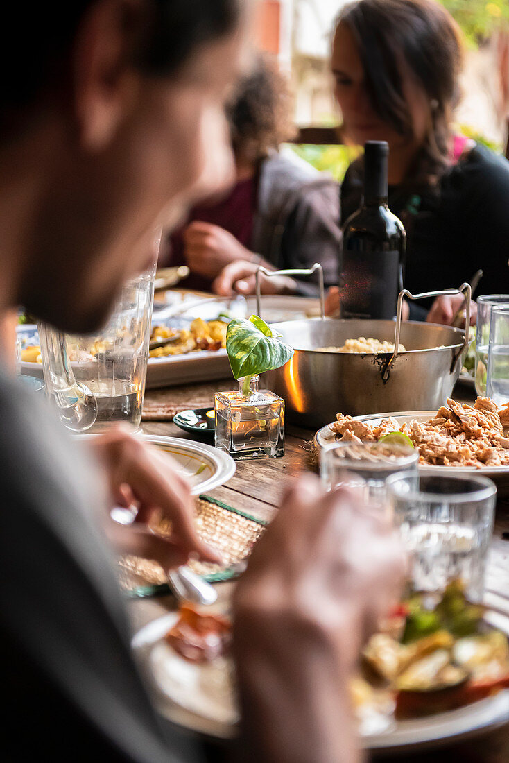 People eating around the table, focus on the food and blurred people
