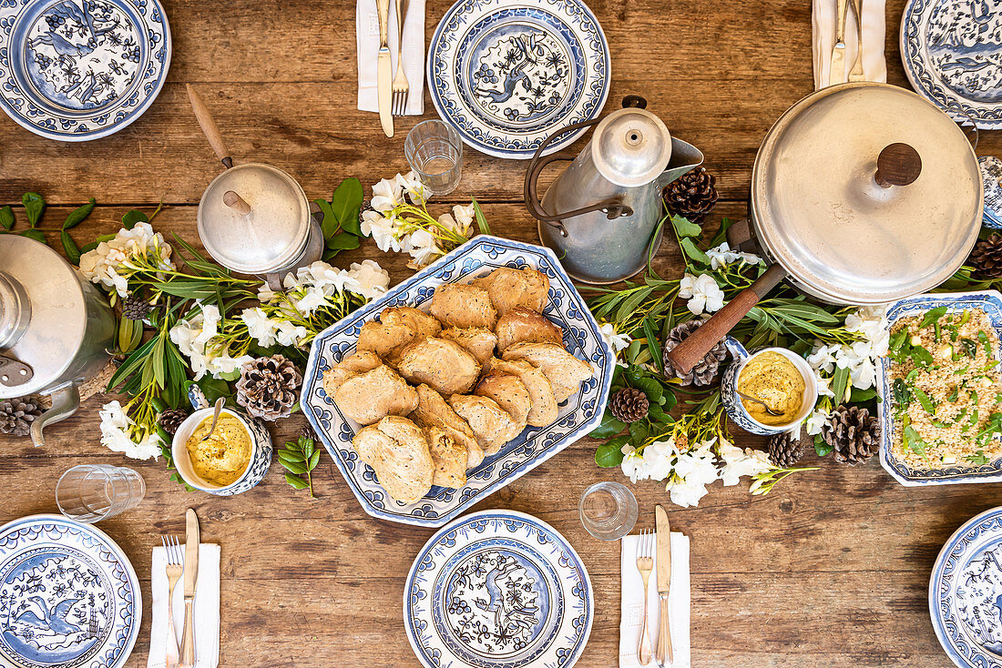 Brot und Salat auf winterlich gedeckter Tisch dekoriert mit Blumen und Zapfen