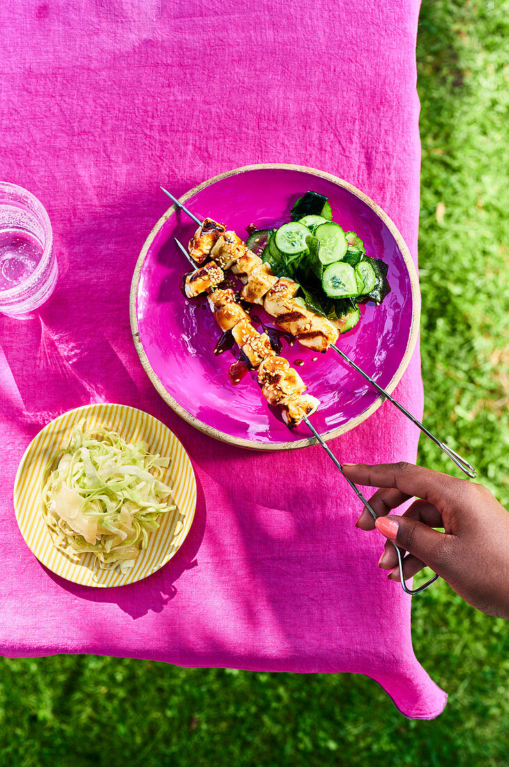 Grilled halloumi skewers with a cucumber and wakame salad, and a ginger and shredded cabbage salad