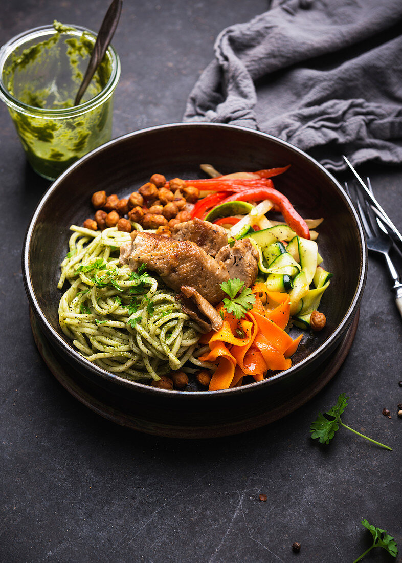 Herb pesto pasta with vegetables, chickpeas and mock duck (vegan duck based on wheat protein)