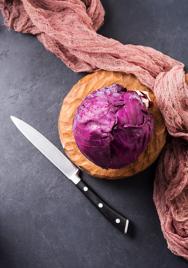 Red cabbage on wooden cutting board ready to be cut