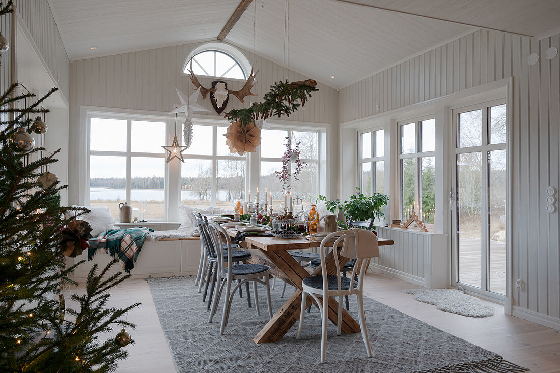 Set table in Scandinavian-style conservatory decorated for Christmas