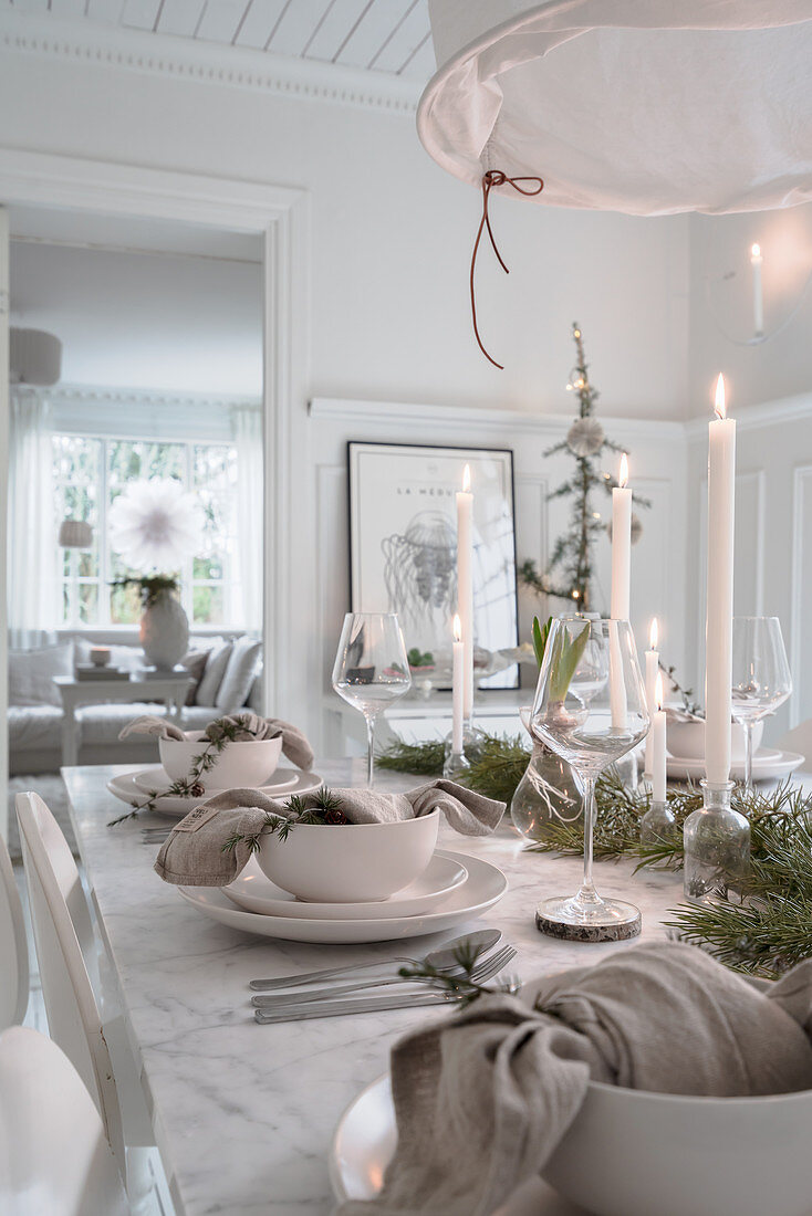 Set table in white dining room decorated for Christmas