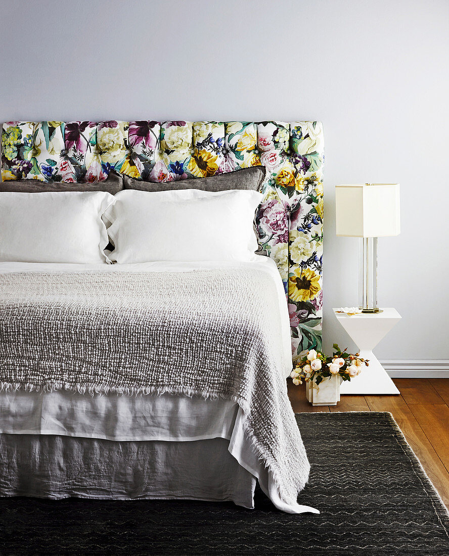 Double bed with headboard upholstered in floral fabric