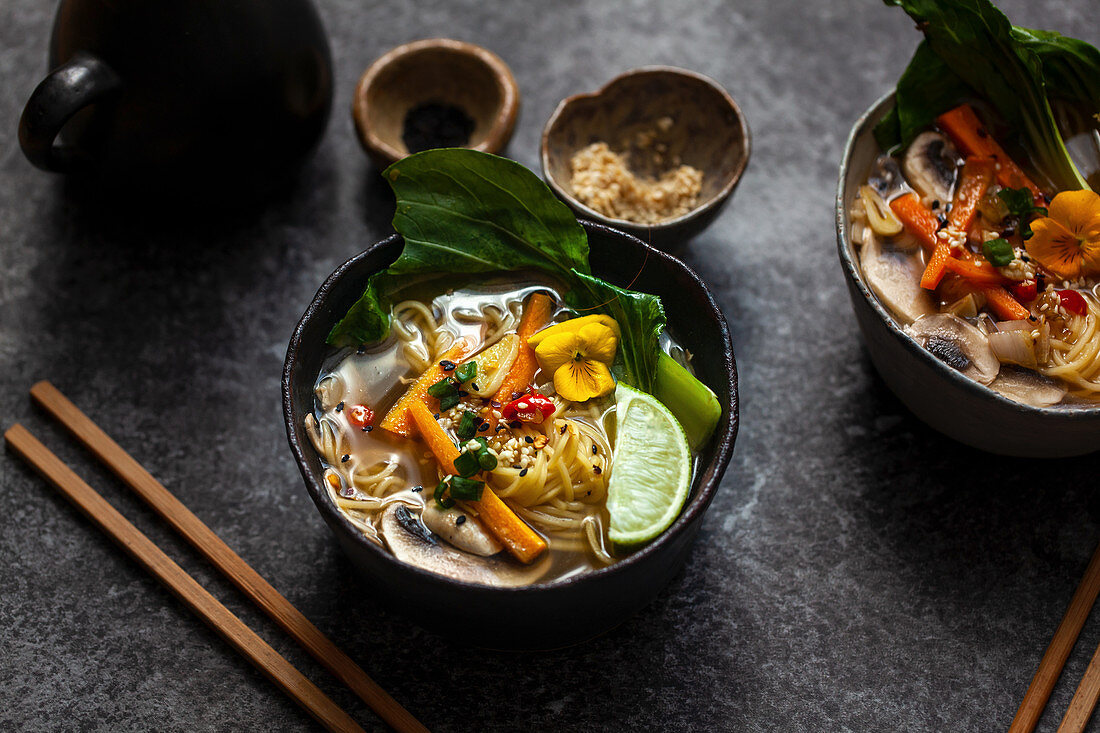 Noodle soup with carrots, mushrooms, pak choi and sesame seeds (Asia)