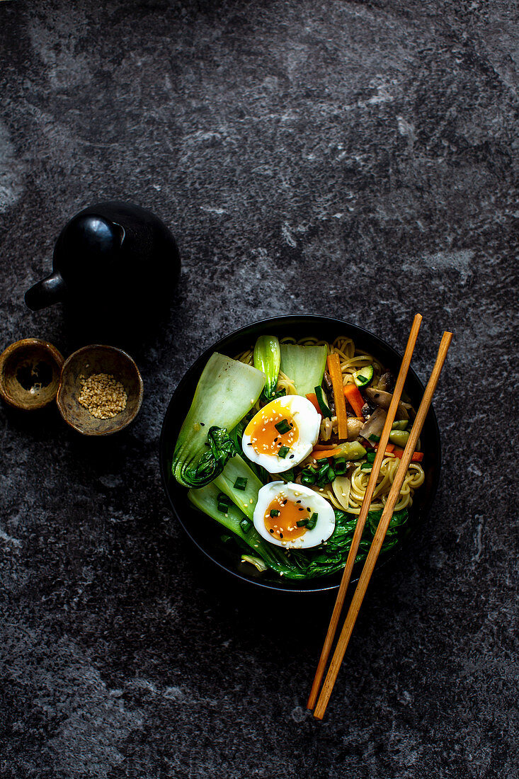 Noodle soup with carrots, mushrooms, pak choi, egg and sesame seeds (Asia)