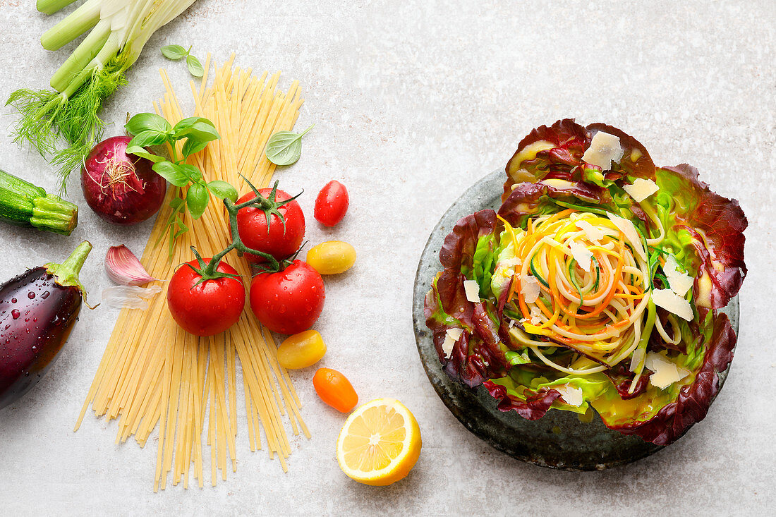 Salat mit Gemüse-Linguine, daneben Zutaten