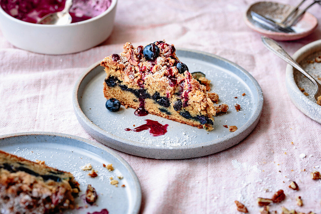 Closeup view of gluten-free blueberry coffee cake with pecan streusel on a plate.
