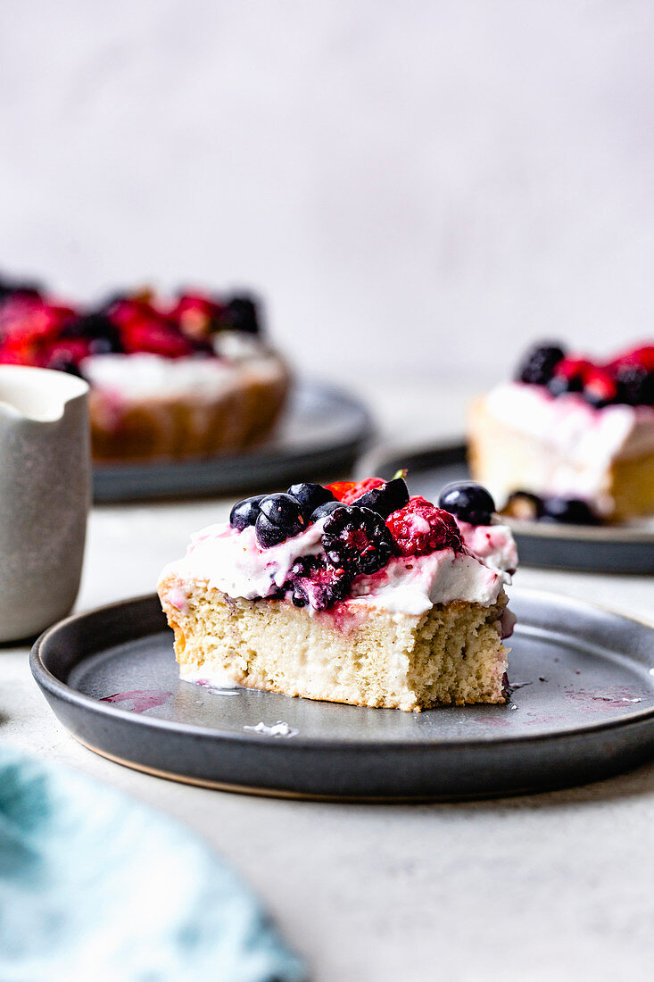 Berry tres leches cake on ceramic plates.