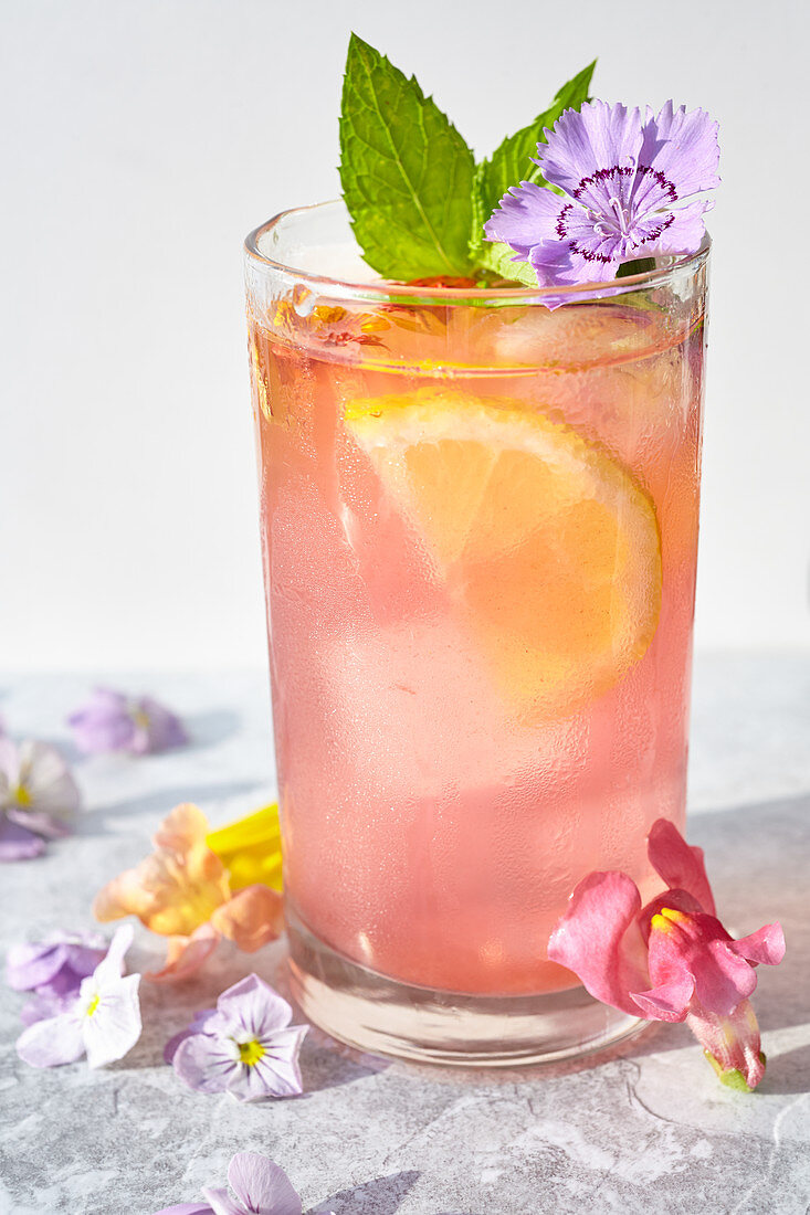 Wassermelonen-Limonade mit Eiswürfeln, Minze und Essblüten