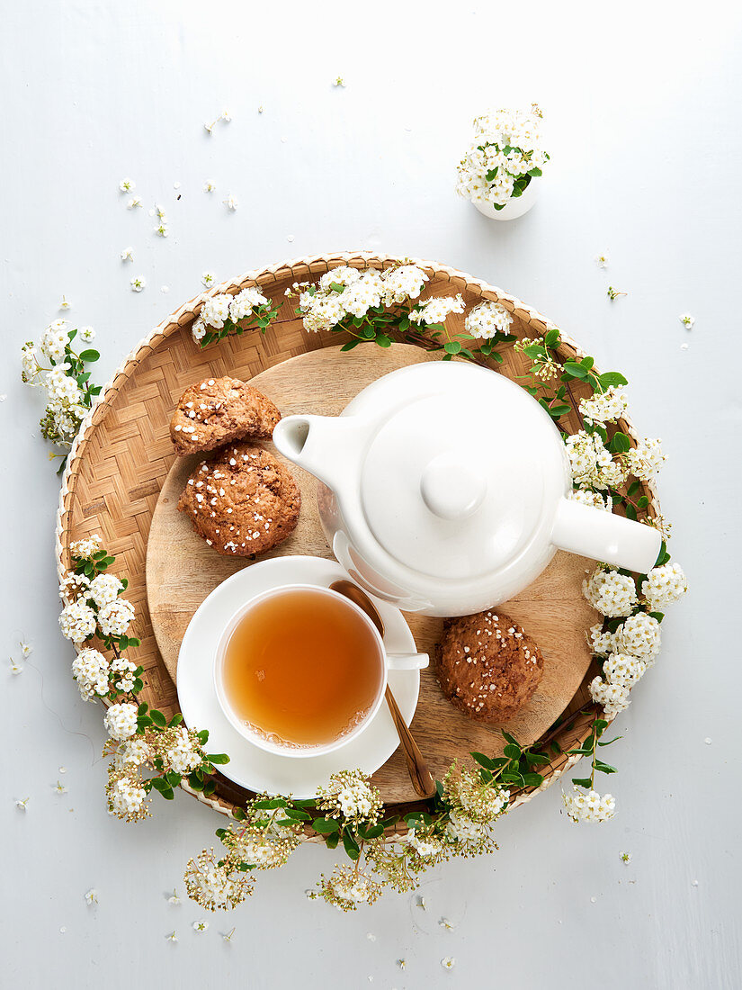 Teetasse, Teekanne, Plätzchen und weiße Blüten