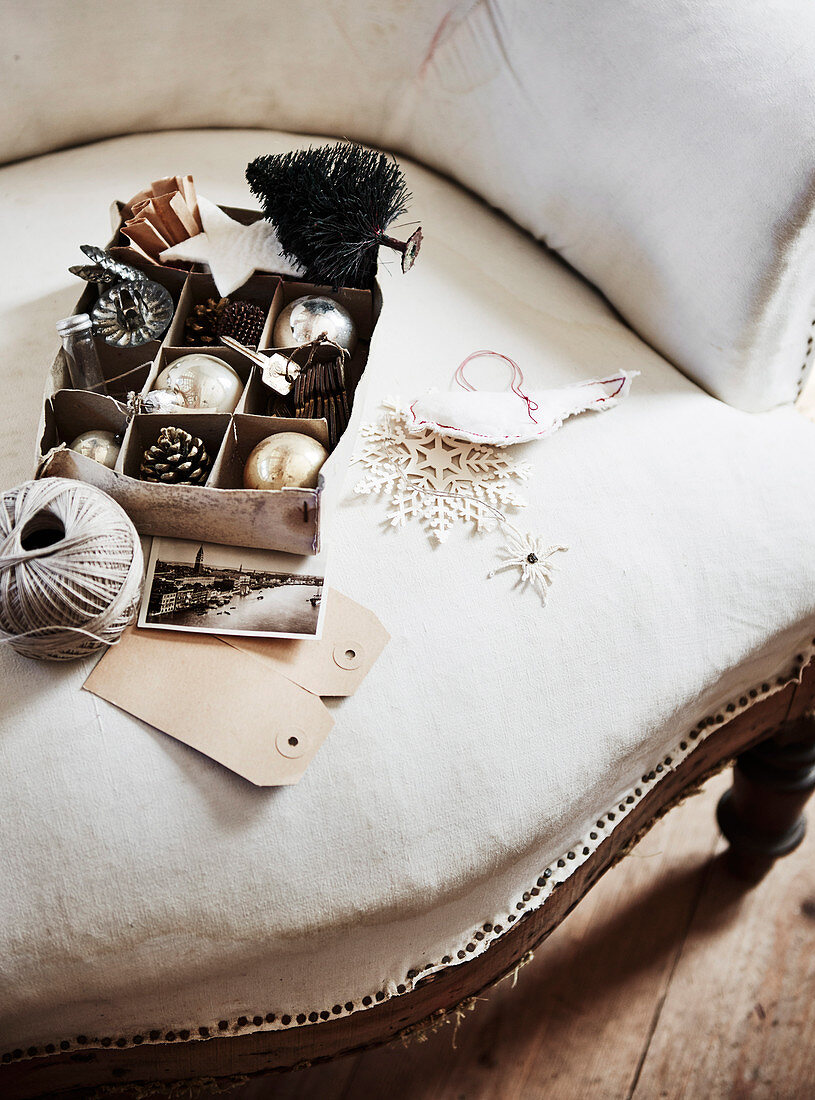 Box with Christmas decoration on antique upholstered chair