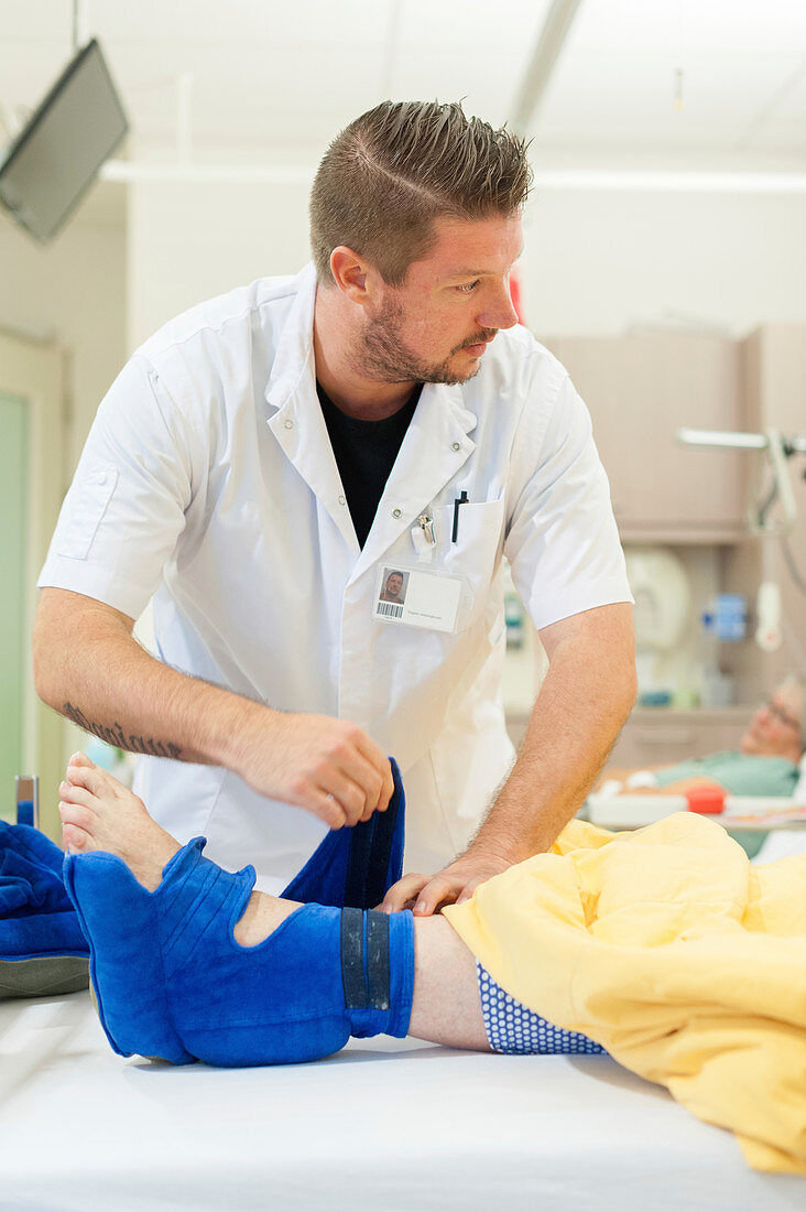 Nurse fitting pressure relief boots on a patient
