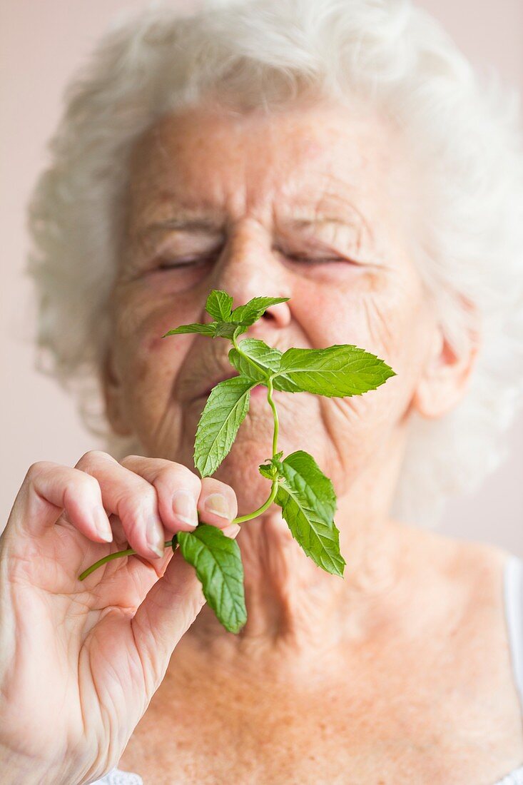 Elderly woman smelling mint
