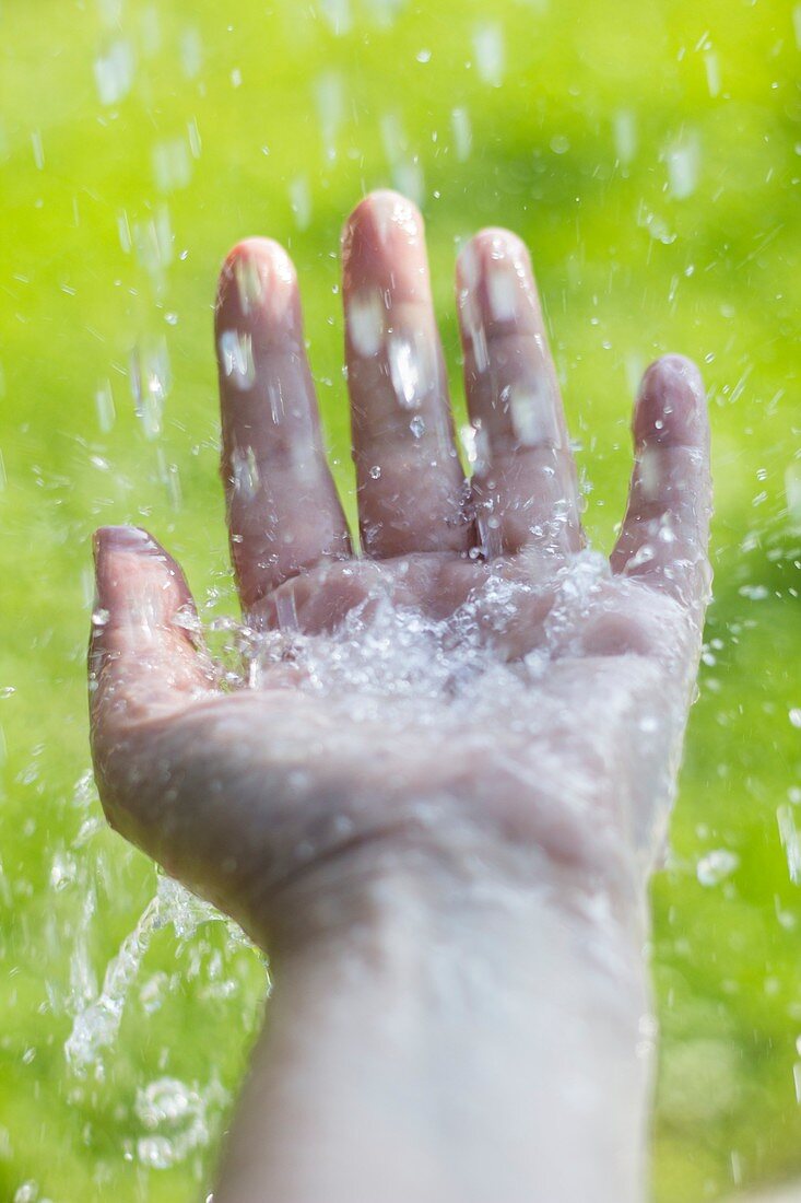 Water splashing on outstretched hand
