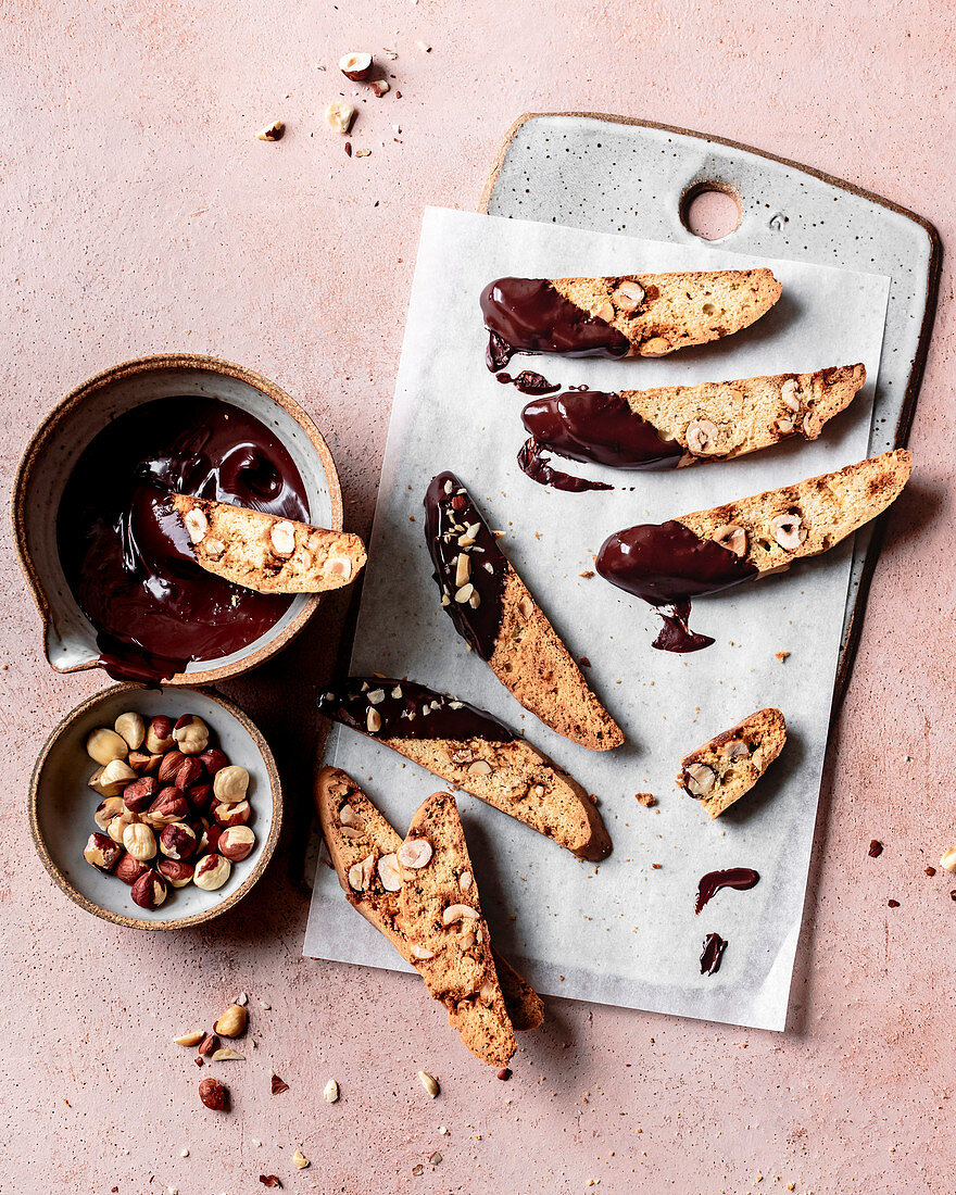 Hazelnut biscotti dipped in a bowl of melted chocolate.