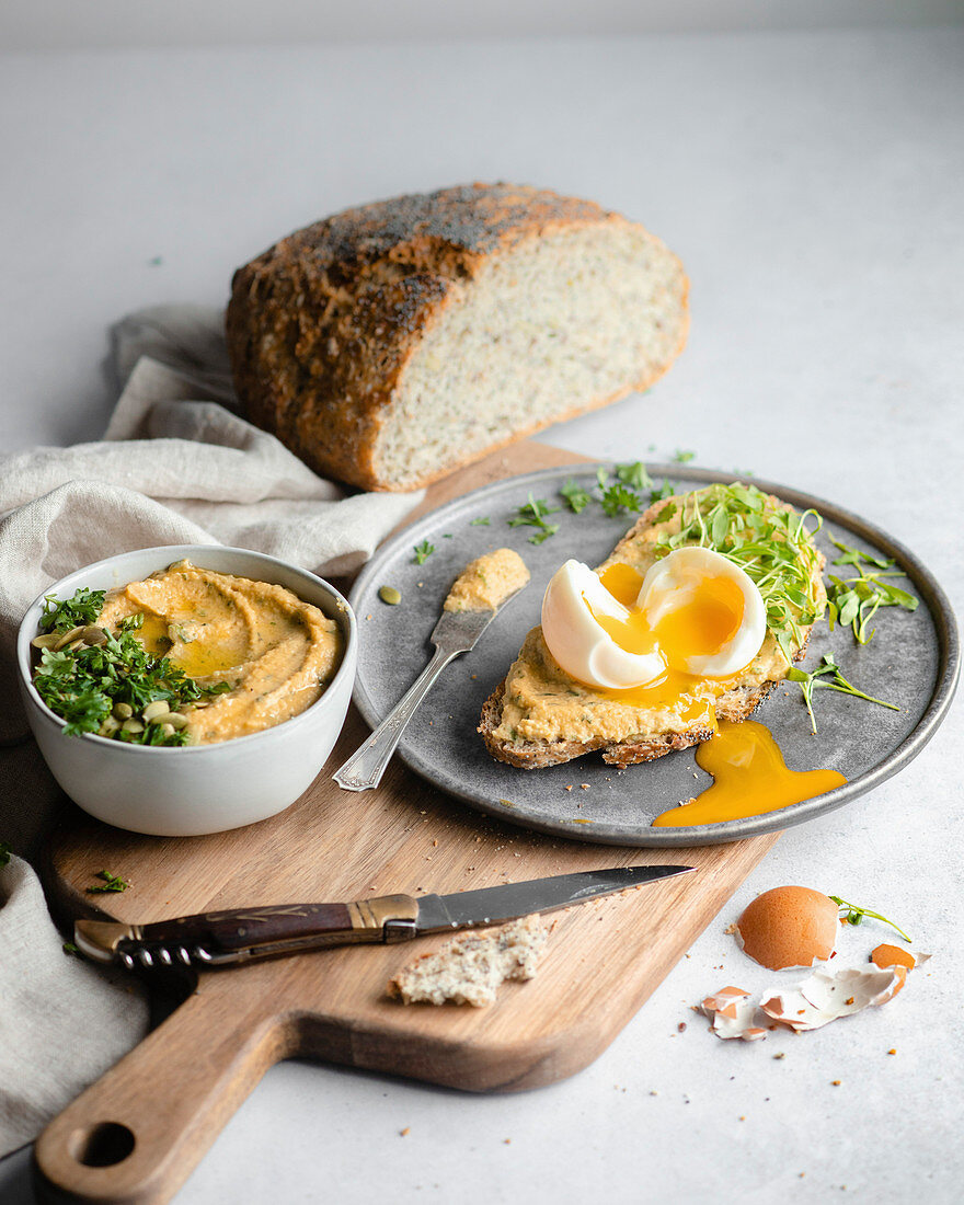 Brotscheibe mit Hummus, Kresse und wachsweichem Ei