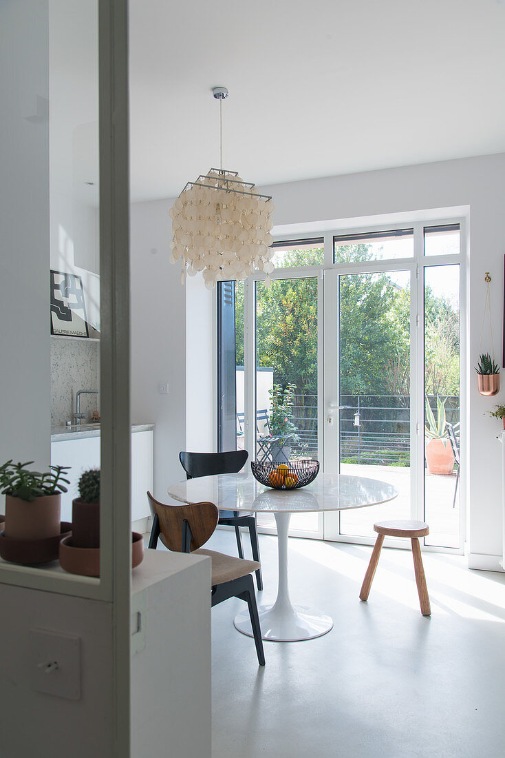 Round classic table next to French windows in kitchen