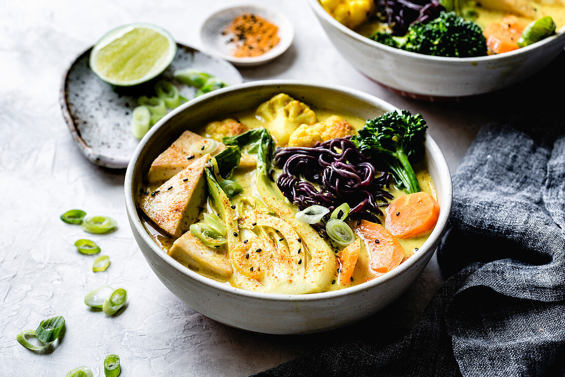 Thai curry with black rice noodles, tofu, carrot, broccolini, bok choy, cauliflower, lime, scallions