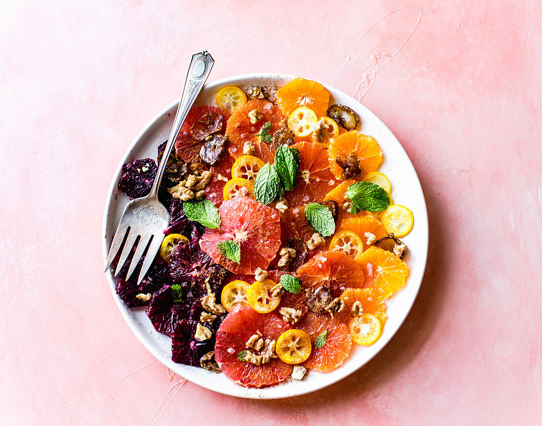 Citrus salad on a plate with a fork.