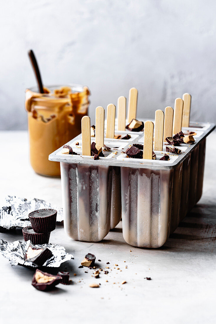 Peanut butter and chocolate fudge popsicles in a plastic mould.