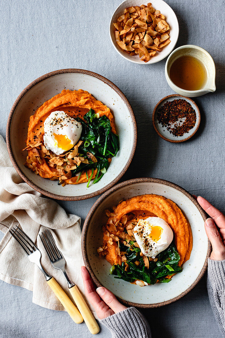 Hands holding a sweet potato breakfast bowl.