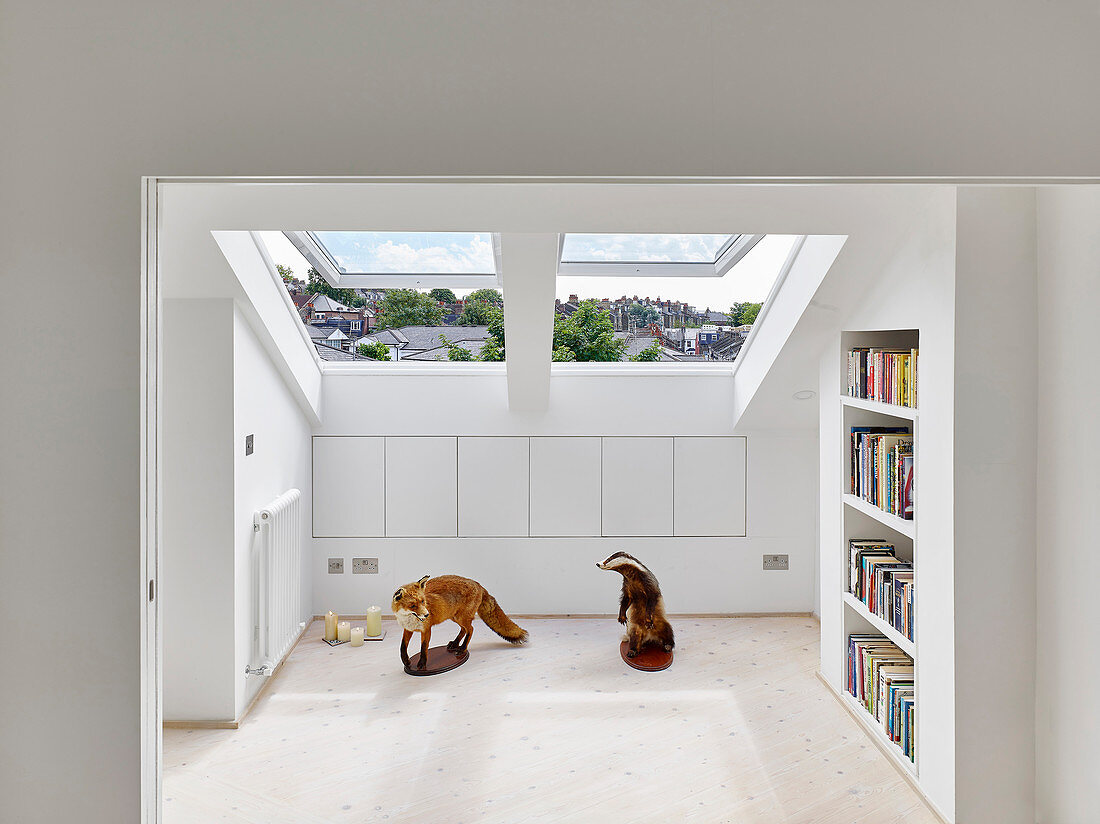 Two stuffed animals in front of fitted cupboards in knee wall