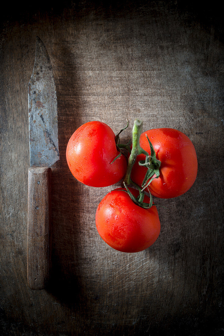 Reife Tomaten mit Rispe und Messer