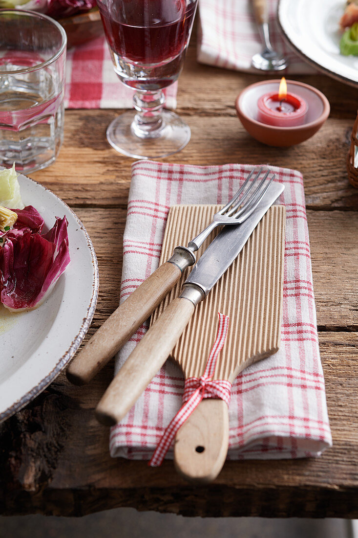 Cloth napkin with wooden boards and cutlery on a rustic table