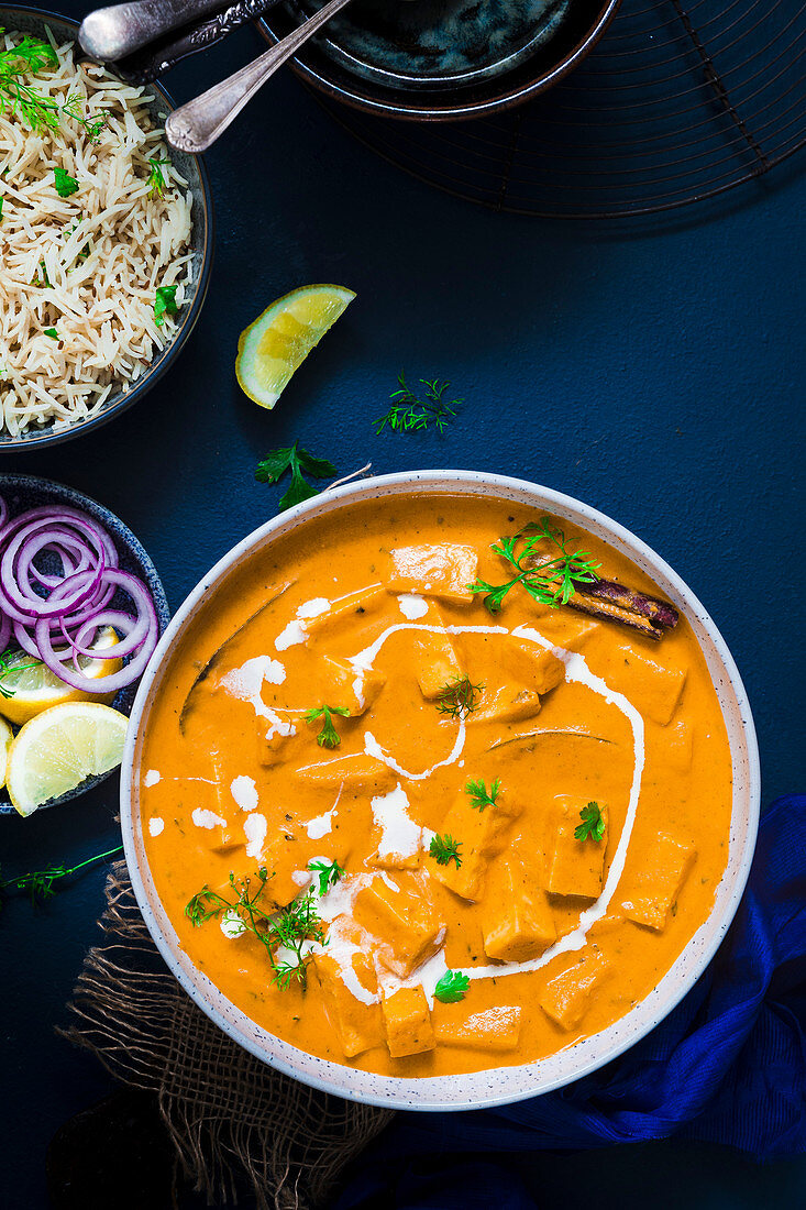 Paneer-Curry serviert mit Kreuzkümmelreis und Salat (Indien)