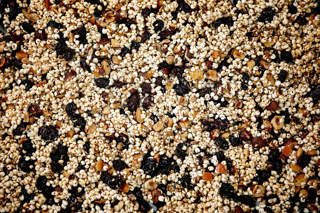 Homemade puffed millet grain granola with dried fruits and nuts as healthy food background. Flat lay, close up