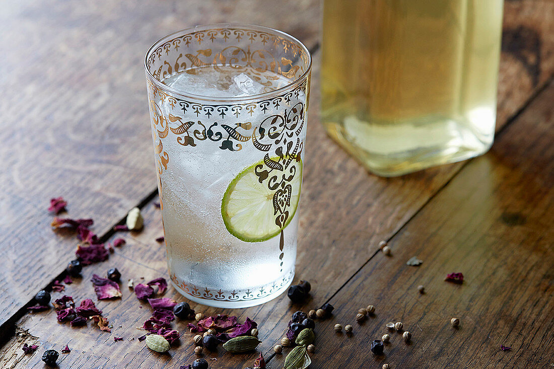 Ein Glas Compound Gin mit Eiswürfeln und Limettenscheibe