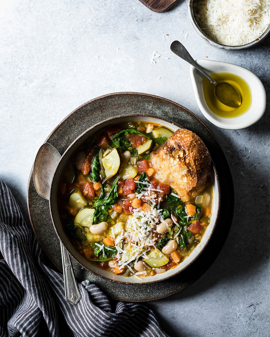 Minestrone mit geriebenem Parmesan und geröstetem Knoblauchbrot