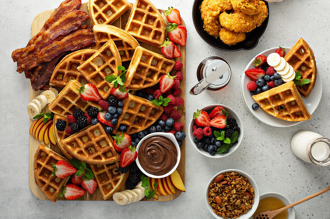 Breakfast with waffles, berries, chicken, bacon and granola