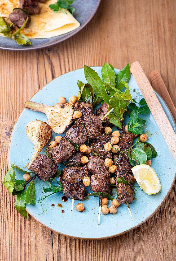Lamb skewers with chickpea salad and grilled garlic