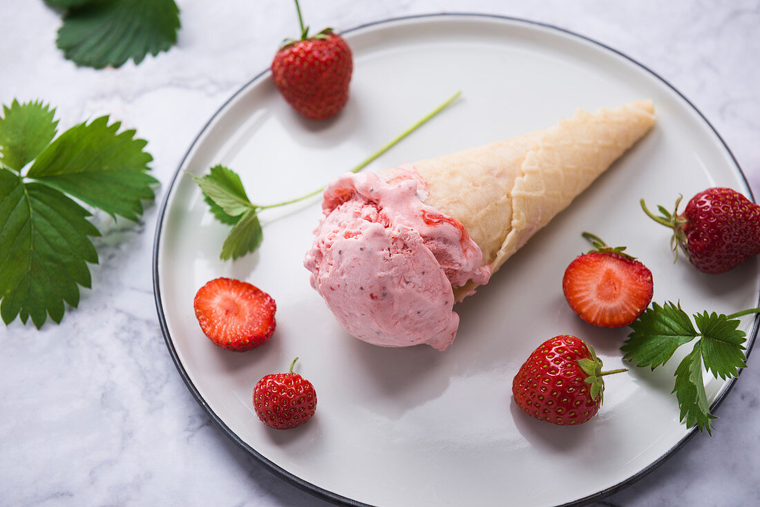 Vegan strawberry ice cream in a waffle cone