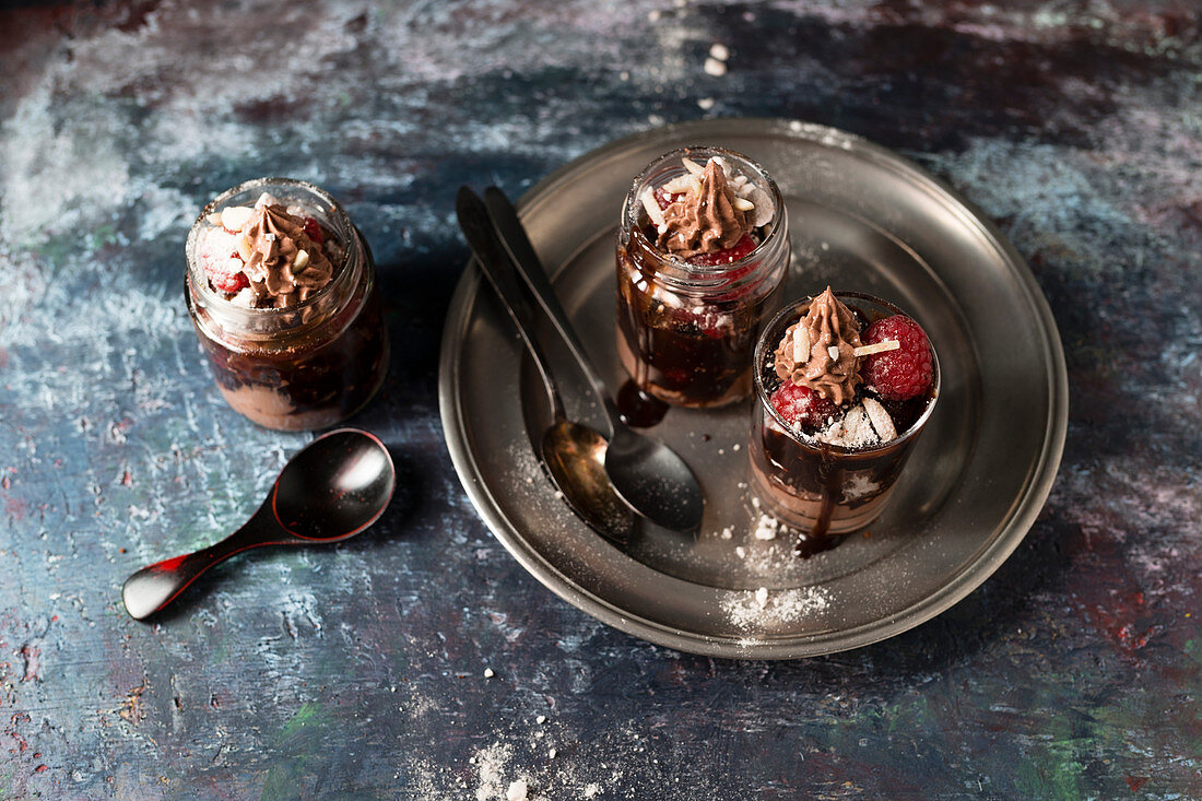 Layered desserts with chocolate cream, pastries, meringue and raspberries