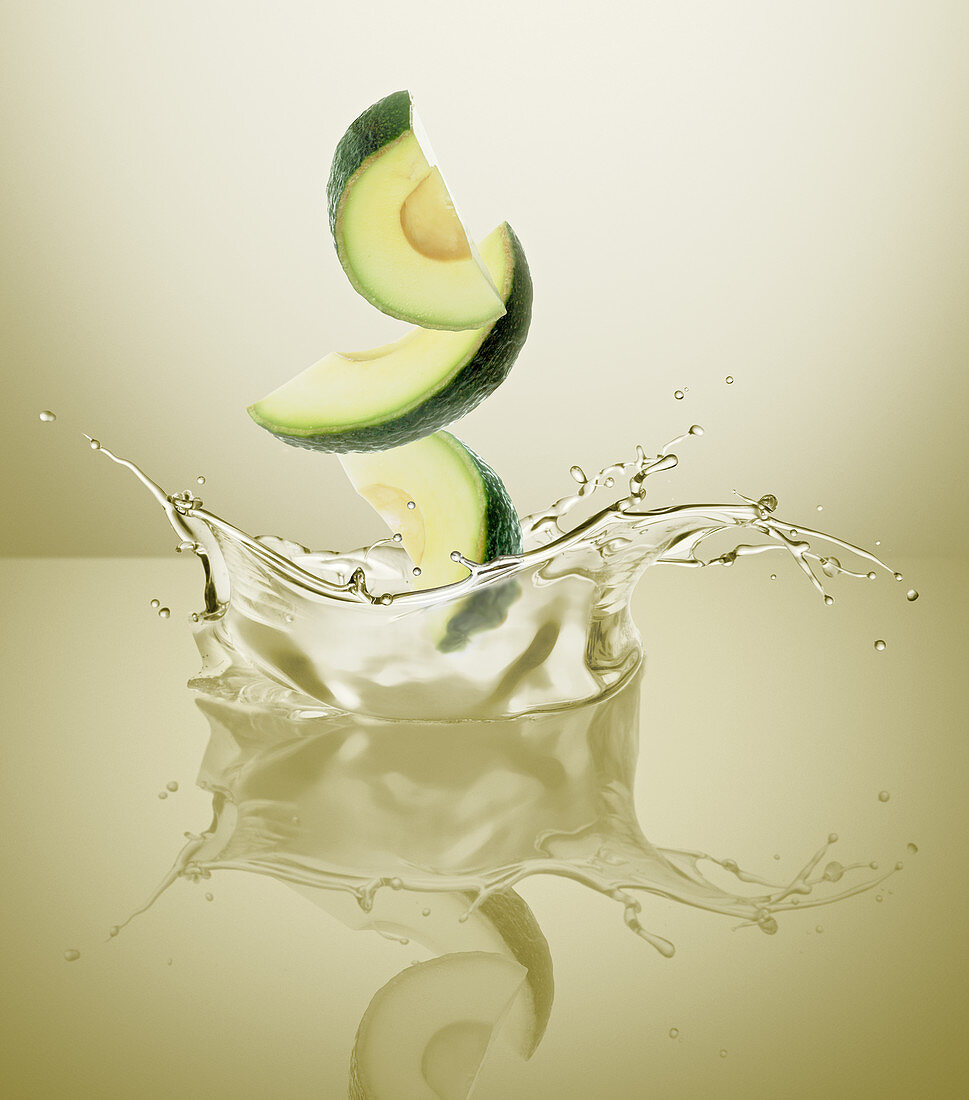 Avocado wedges splashing into oil