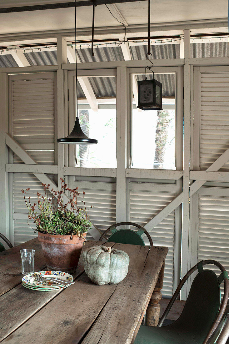 Dining area in summer house made of recycled shutters