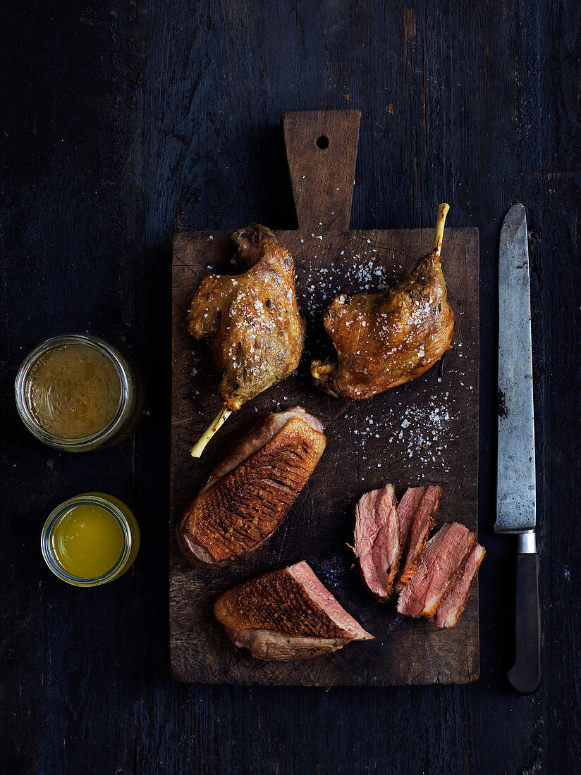 Roasted duck legs on a wooden chopping board