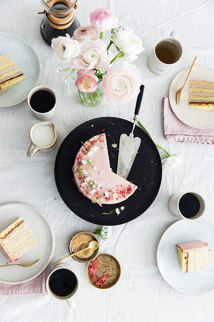 A strawberry cream cake on spring table laid for coffee
