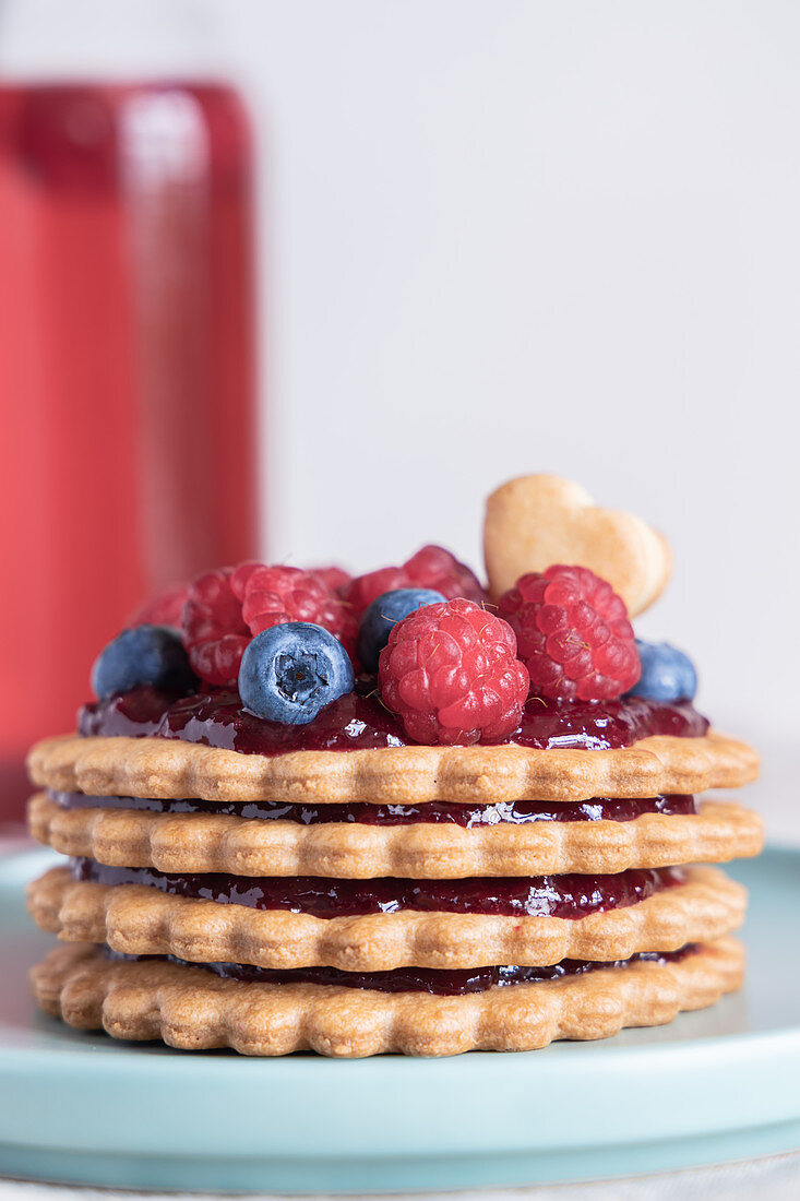 A layered biscuit tower with jam and berries