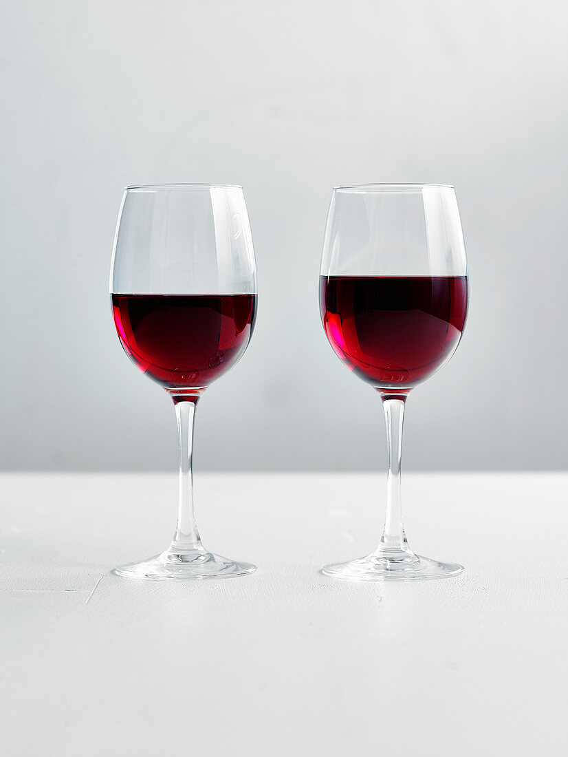 Zwei Gläser Rotwein vor weißem Hintergrund